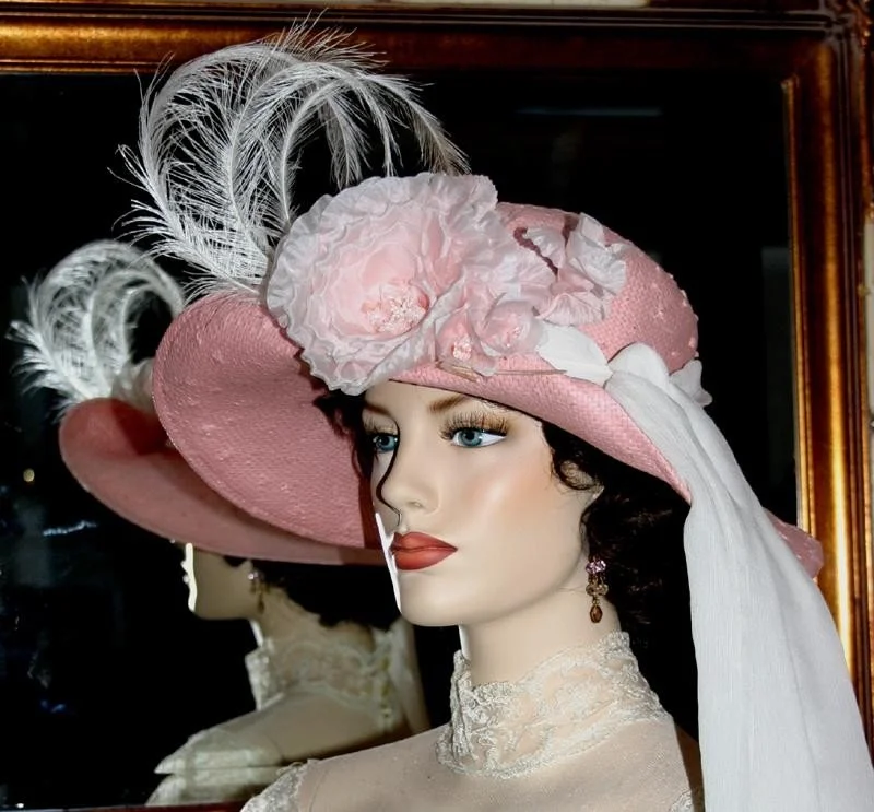 Beautiful toyo straw hat in pink adorned with feathers and white organza rose.