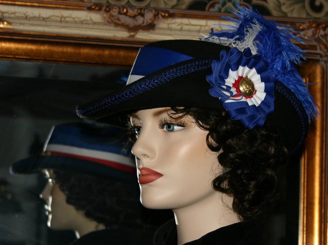 Side view of Spirit of Iowa Victorian hat showcasing patriotic ribbon and cockade.