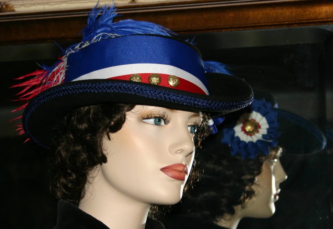 Side view of Spirit of Iowa Victorian hat showcasing patriotic ribbon, cockade, and vintage brass Civil War button details.