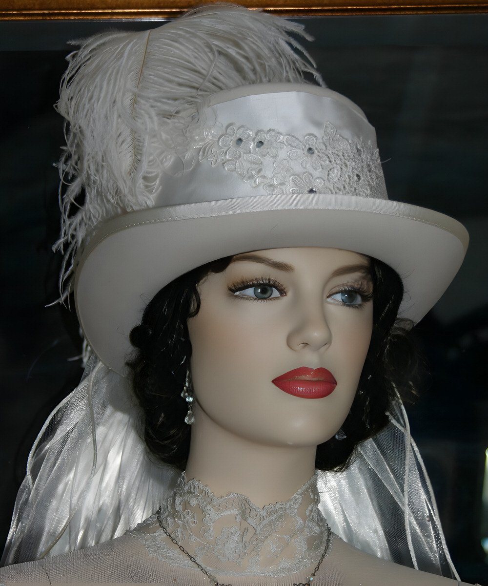 Ivory White top hat adorned with silk and a rhinestone applique.