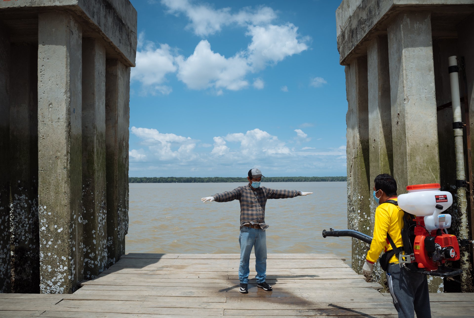 Victoriano Vera, 49, a certified public accountant, is sprayed with a chlorine solution, which has become a standard procedure for every person and boat arriving at the town pier during the coronavirus disease (COVID-19) outbreak, in Puerto Roma, Ecu