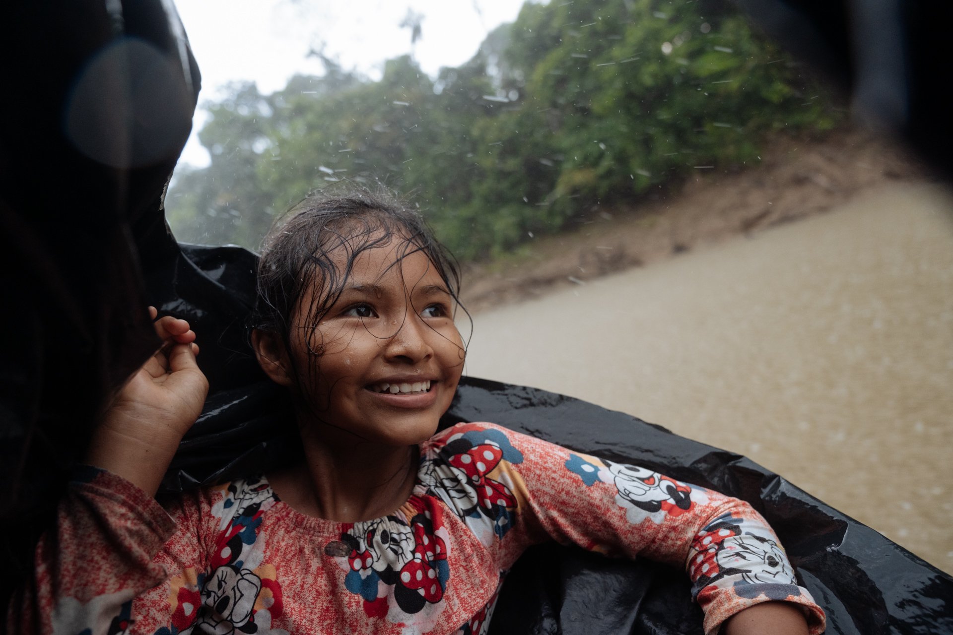 Sasha Machoa enjoys the rain while returning home on her dad's canoe after a walk through the Yasuni National Park. She wants to be a tourist guide when she grows up to show everyone how beautiful her home is.