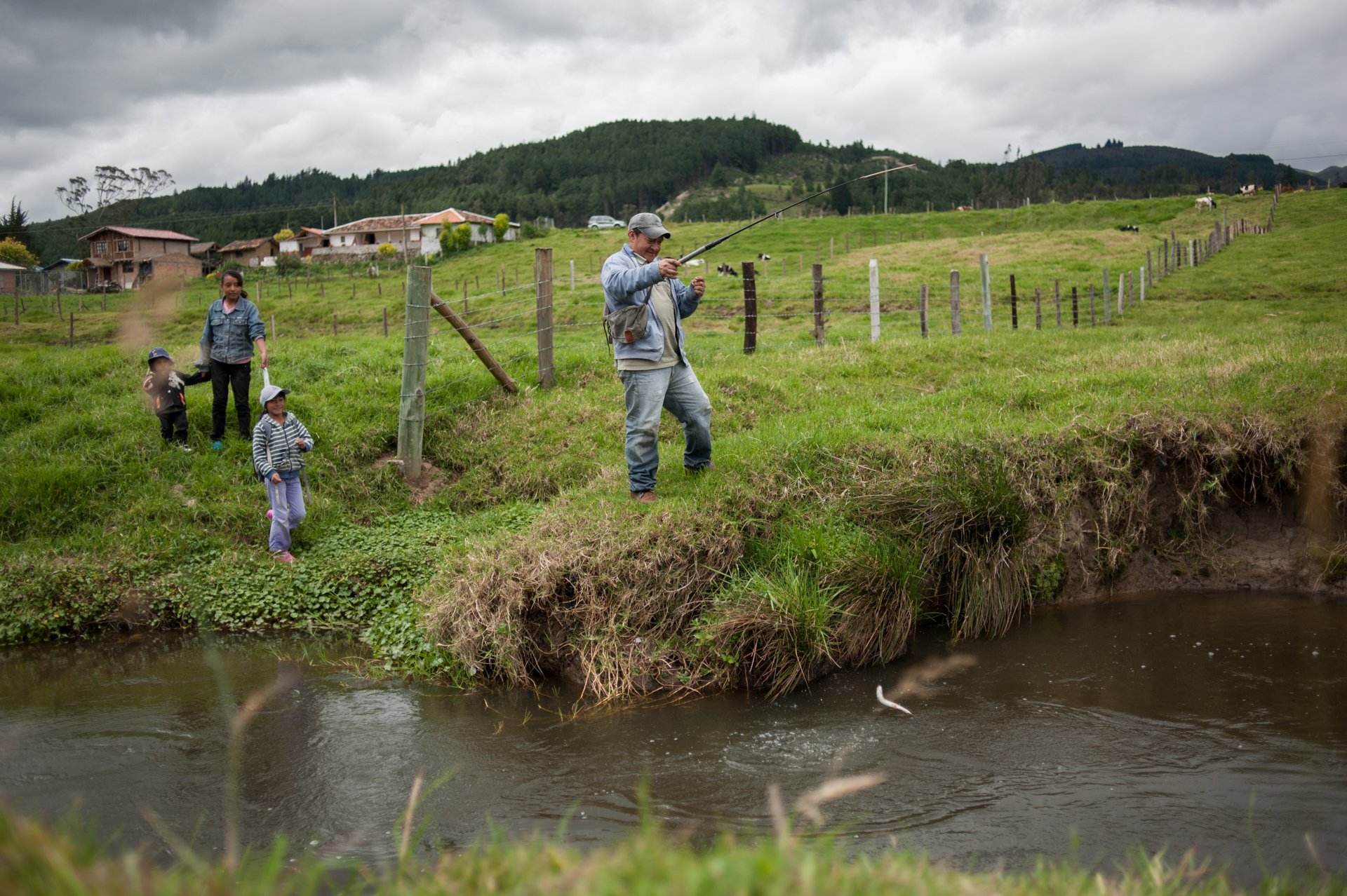Sergio Palta fishes trouts in the river Irquis with his three daughters during a Sunday morning. During the exploration stage of mineral settlements in Quimsacocha, 2003, the pollution in the river killed much of their fish. Once the exploring ended,