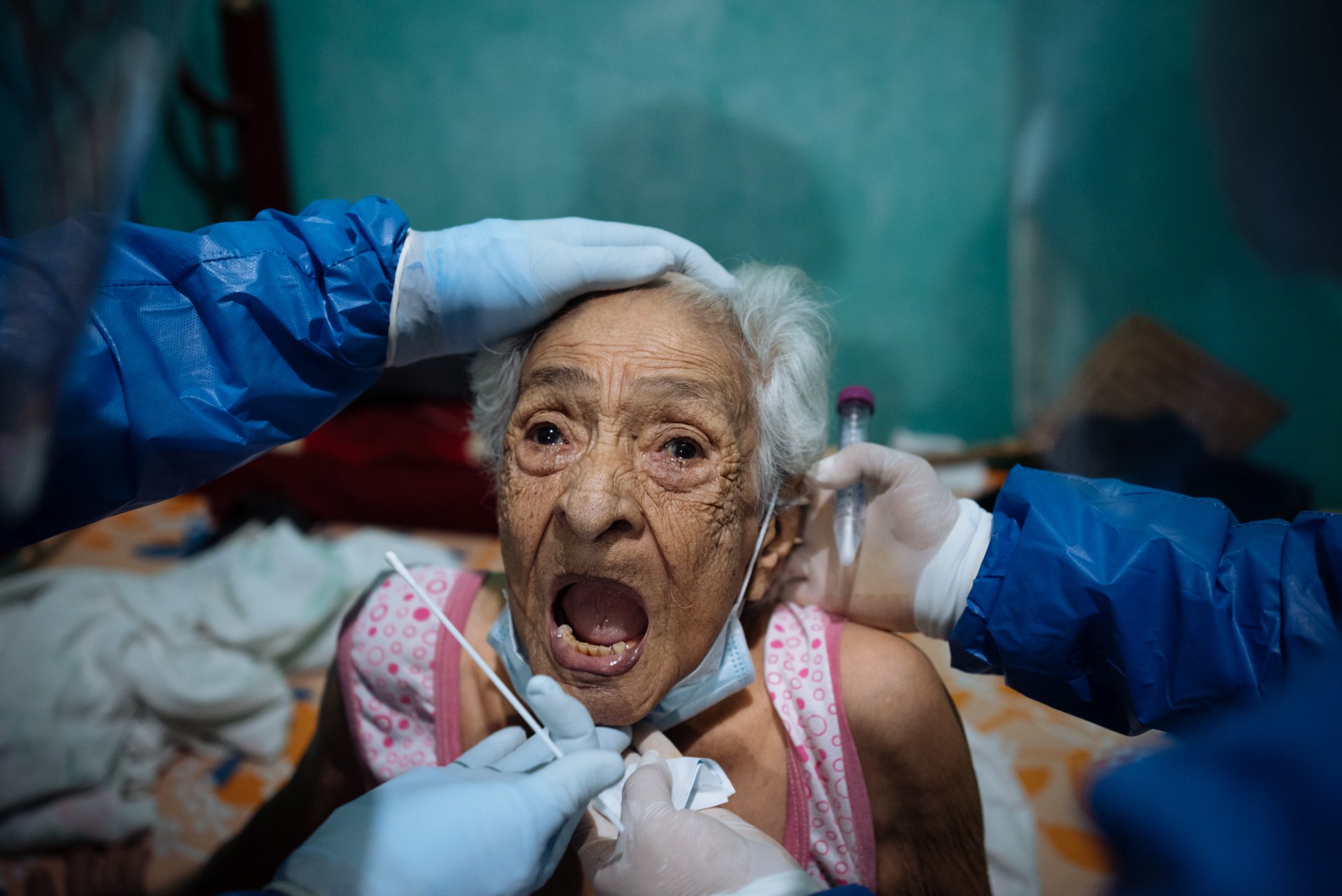 A 94-year-old woman prepares to have a sample taken by doctors from the Ecuadorian health ministry's rapid response team for the coronavirus disease (COVID-19) after showing symptoms of the disease, at her home in Guayaquil, Ecuador