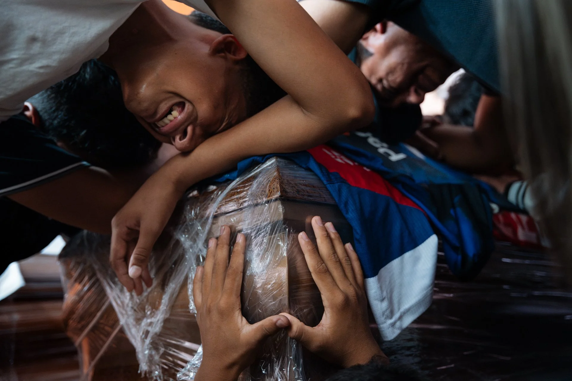 Teammates and the coach of a local football team mourn over the coffin of 15-year-old Ismael Arroyo at his family’s home in the Las Malvinas neighborhood, in southern Guayaquil.