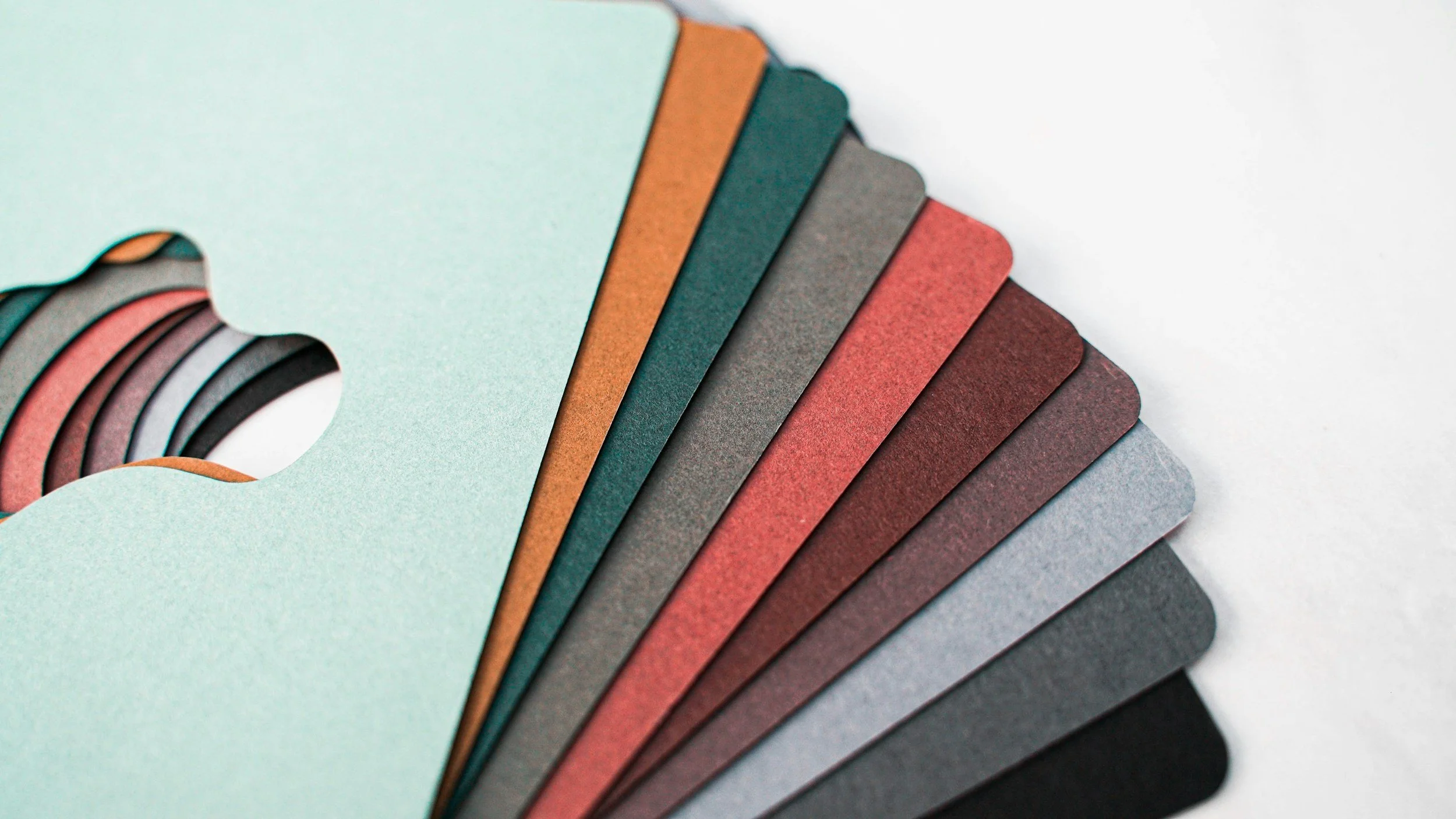 A color palette featuring various pastel and earthy tones, including shades of green, orange, gray, red, and black.