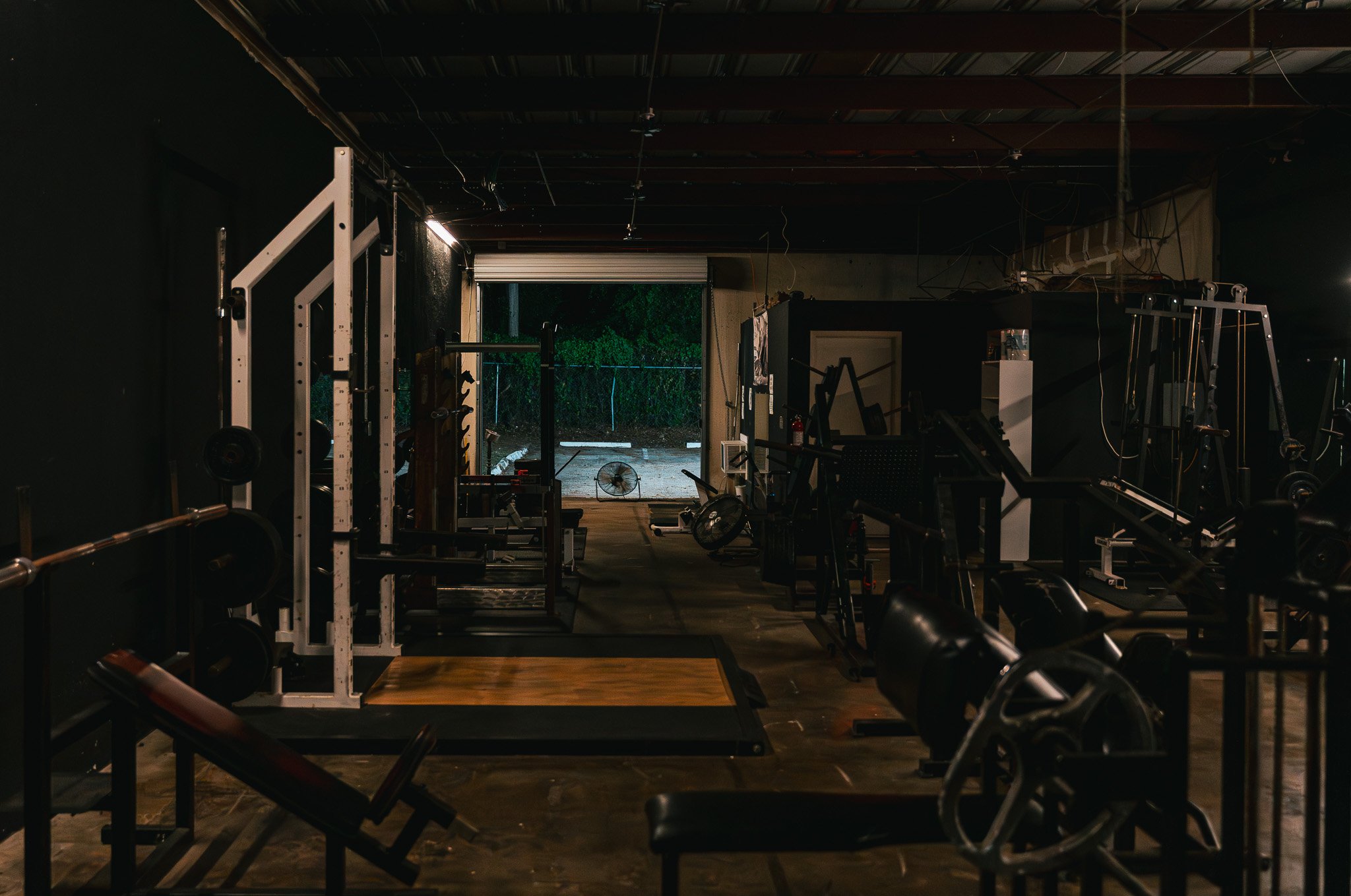 Open bay door and strength equipment across The Forge Gym floor