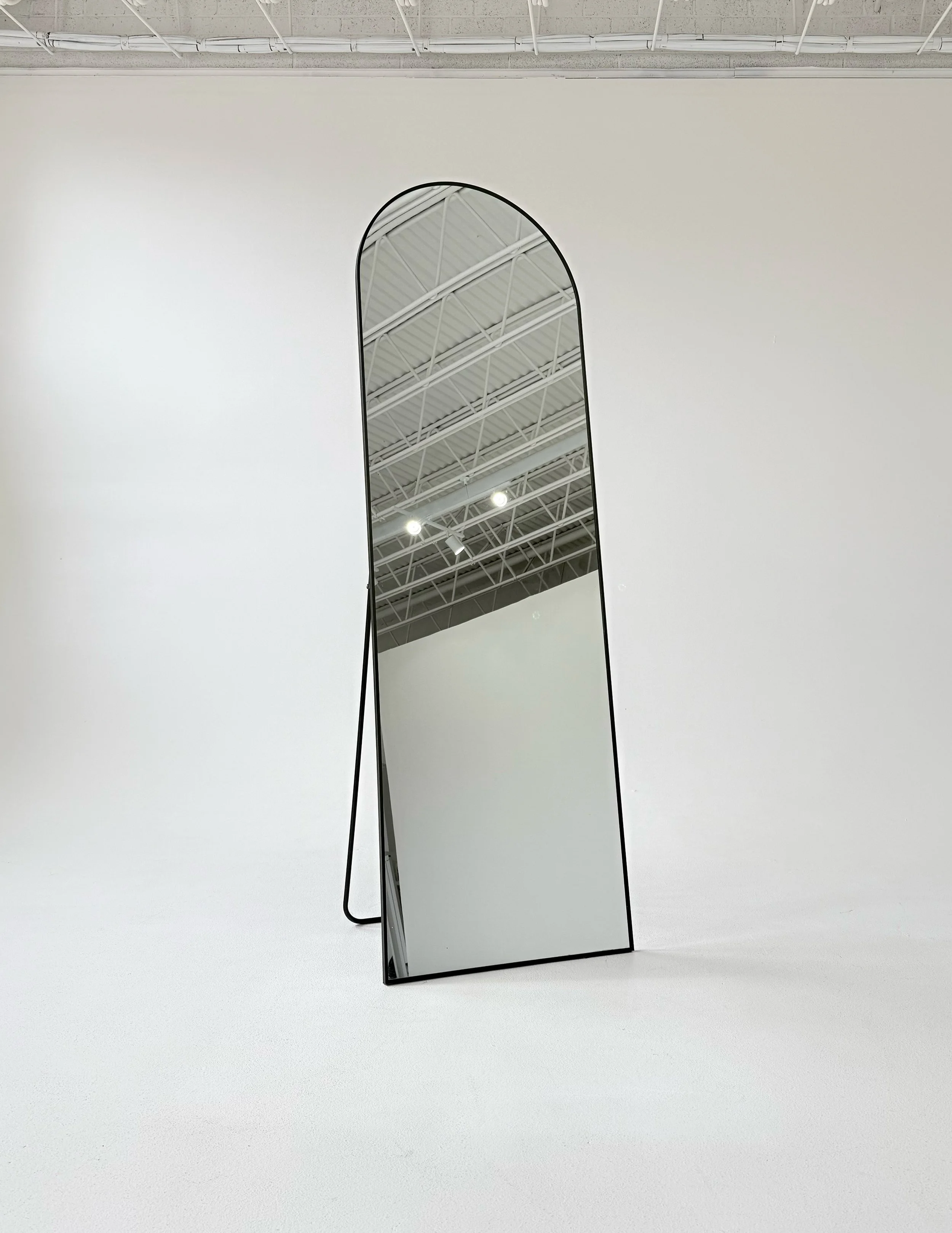 Black arched mirror at Sixteenth St. Studio in Greeley, Colorado