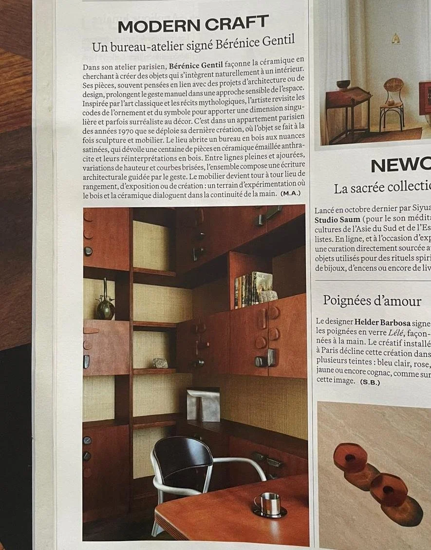 Photo d'un bureau avec bibliothèque en bois, un bureau en bois, une chaise noir et blanc, ainsi qu'une petite coupelle en métal sur le bureau. Le meuble est habiller d'une centaine de poignées en céramique et leur réplique en bois.