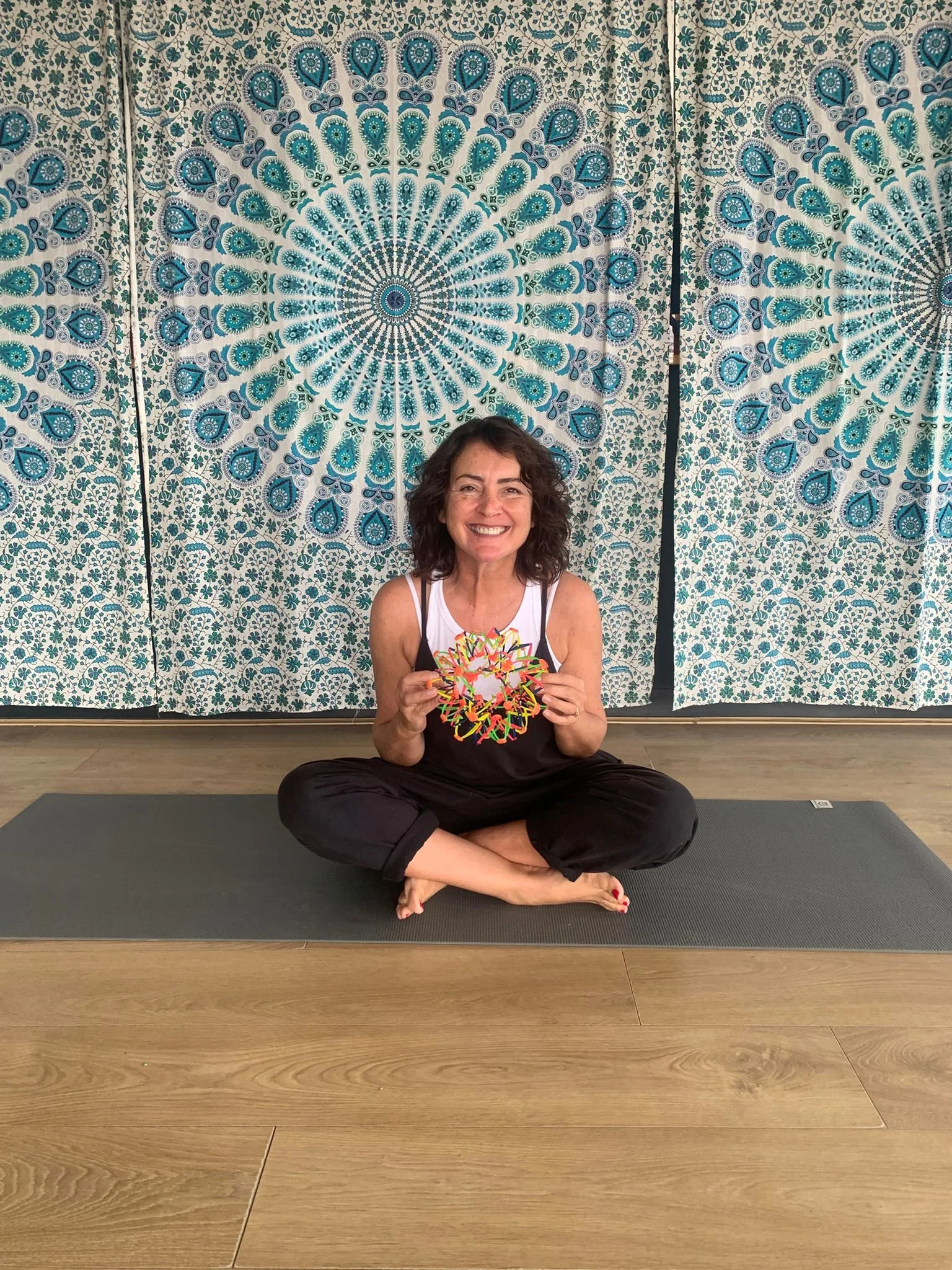 Helen of Jasmine Yoga sits crossed legged for a children's yoga class in tynemouth