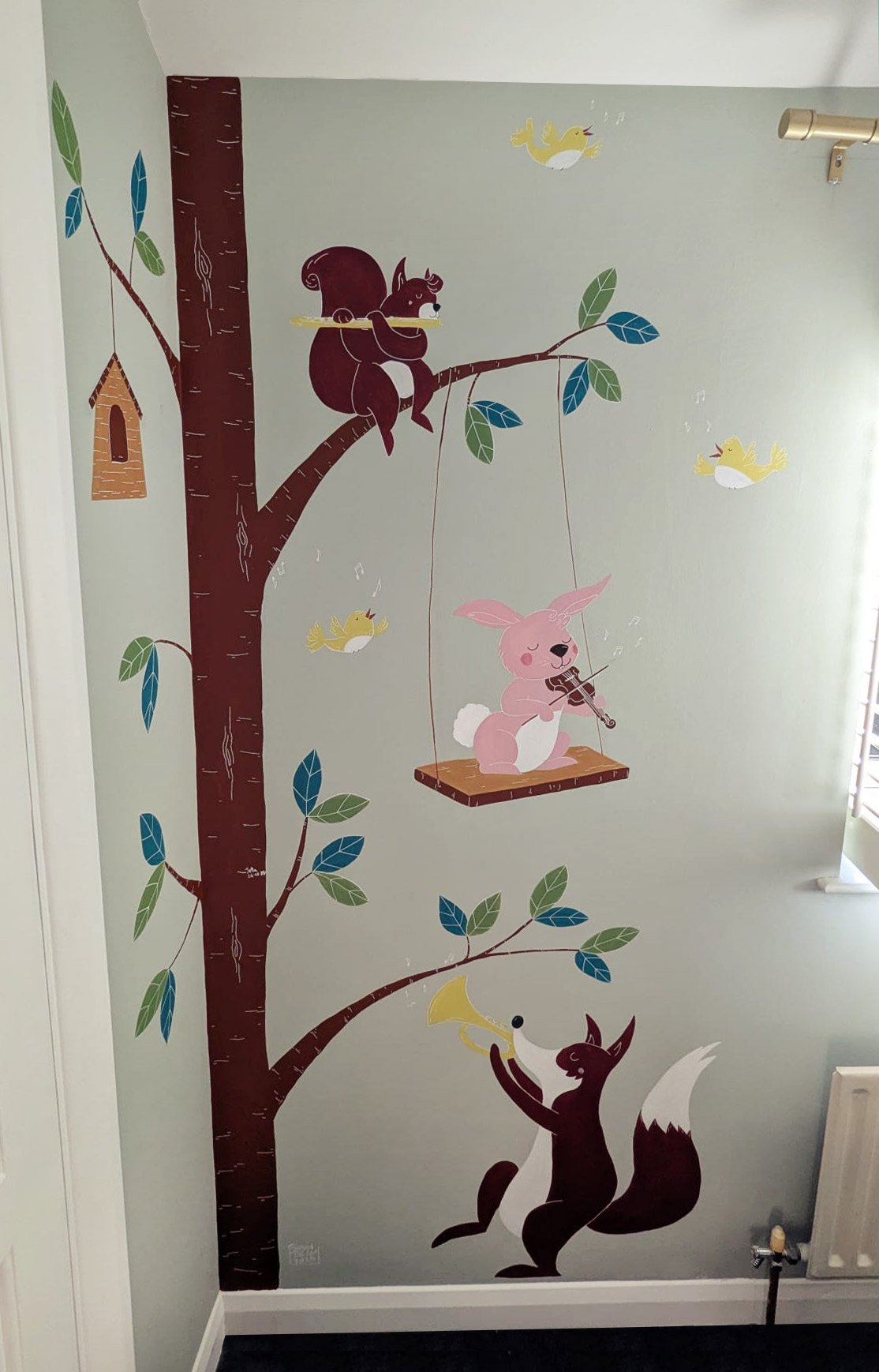 Wall mural depicting a tree with a squirrel playing a flute, a pink rabbit playing a violin sitting on a swing, and a fox playing a trumpet, with flying yellow birds around.