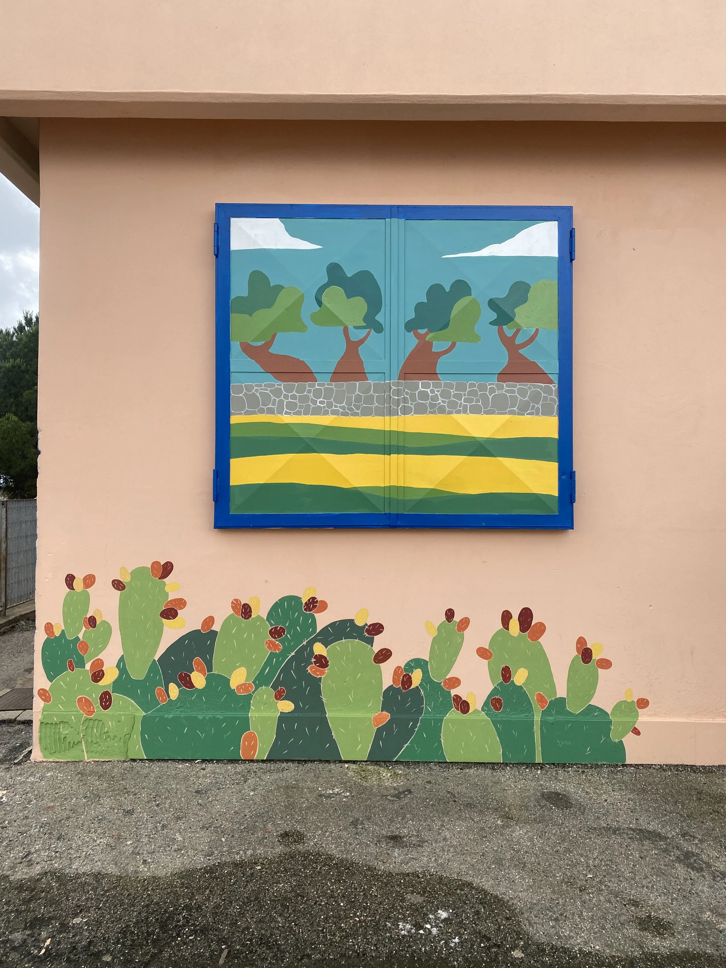 Wall mural featuring a landscape scene of trees and a stone wall, with abstract yellow and green fields below, and potted cactus plants painted along the bottom of the wall.