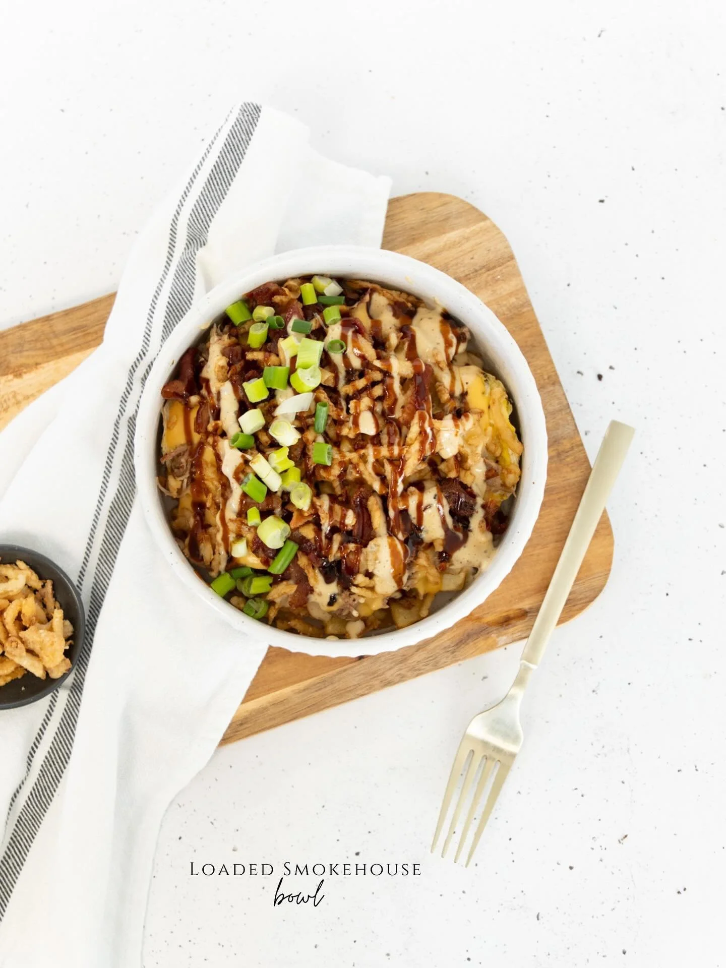 Crispy, golden homefries piled with tender pulled pork, fluffy scrambled eggs, and smoky bacon, all smothered in warm cheese sauce. Finished with crunchy onions, a drizzle of Alabama and BBQ sauces, and a sprinkle of green onions&mdash;the perfect he