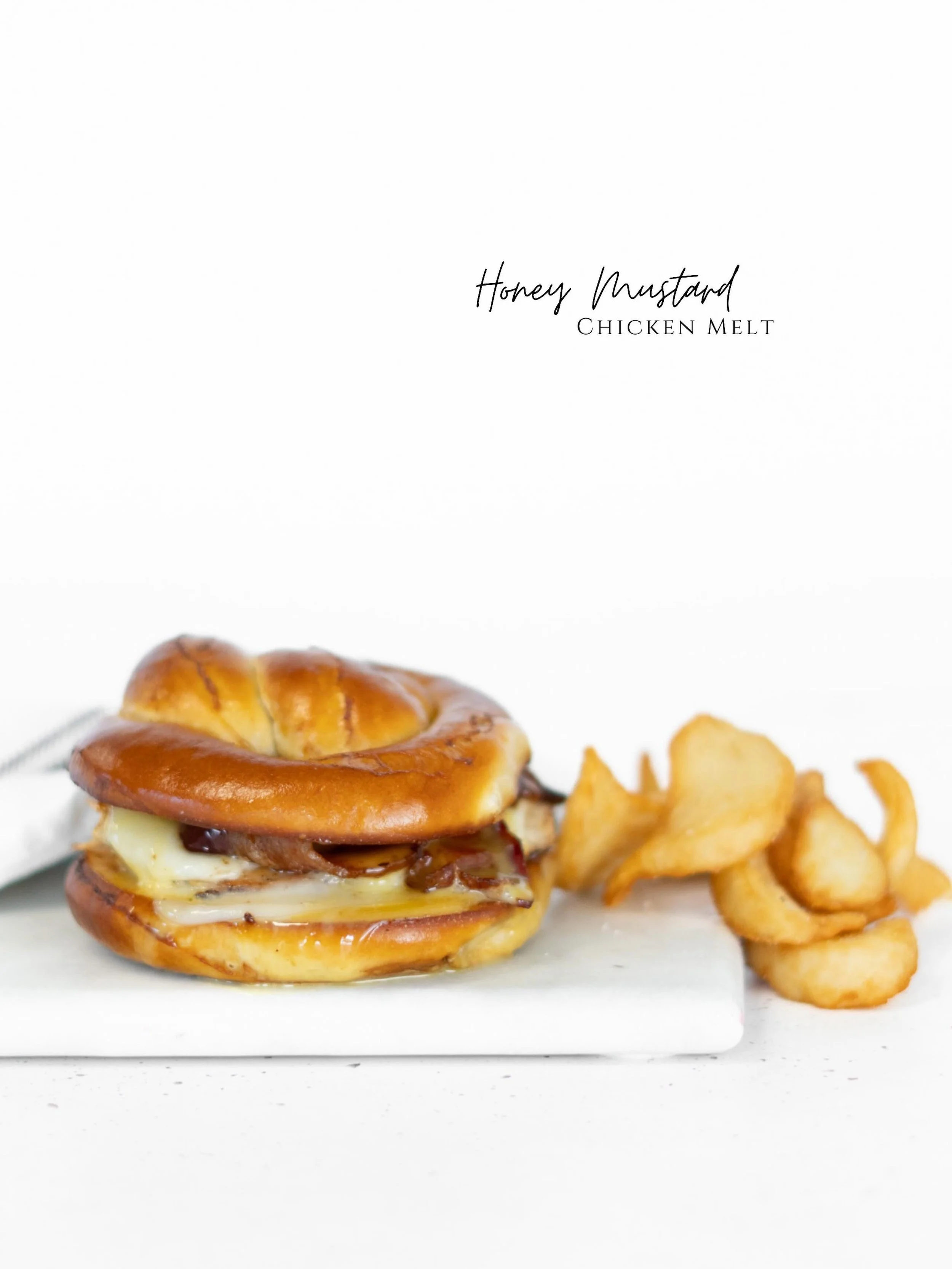 Tender grilled chicken stacked with smoky crispy bacon and melted mozzarella, all tucked into a warm pretzel bun. Finished with a drizzle of sweet, tangy honey mustard that ties everything together, it&rsquo;s savory, melty, and just the right kind o