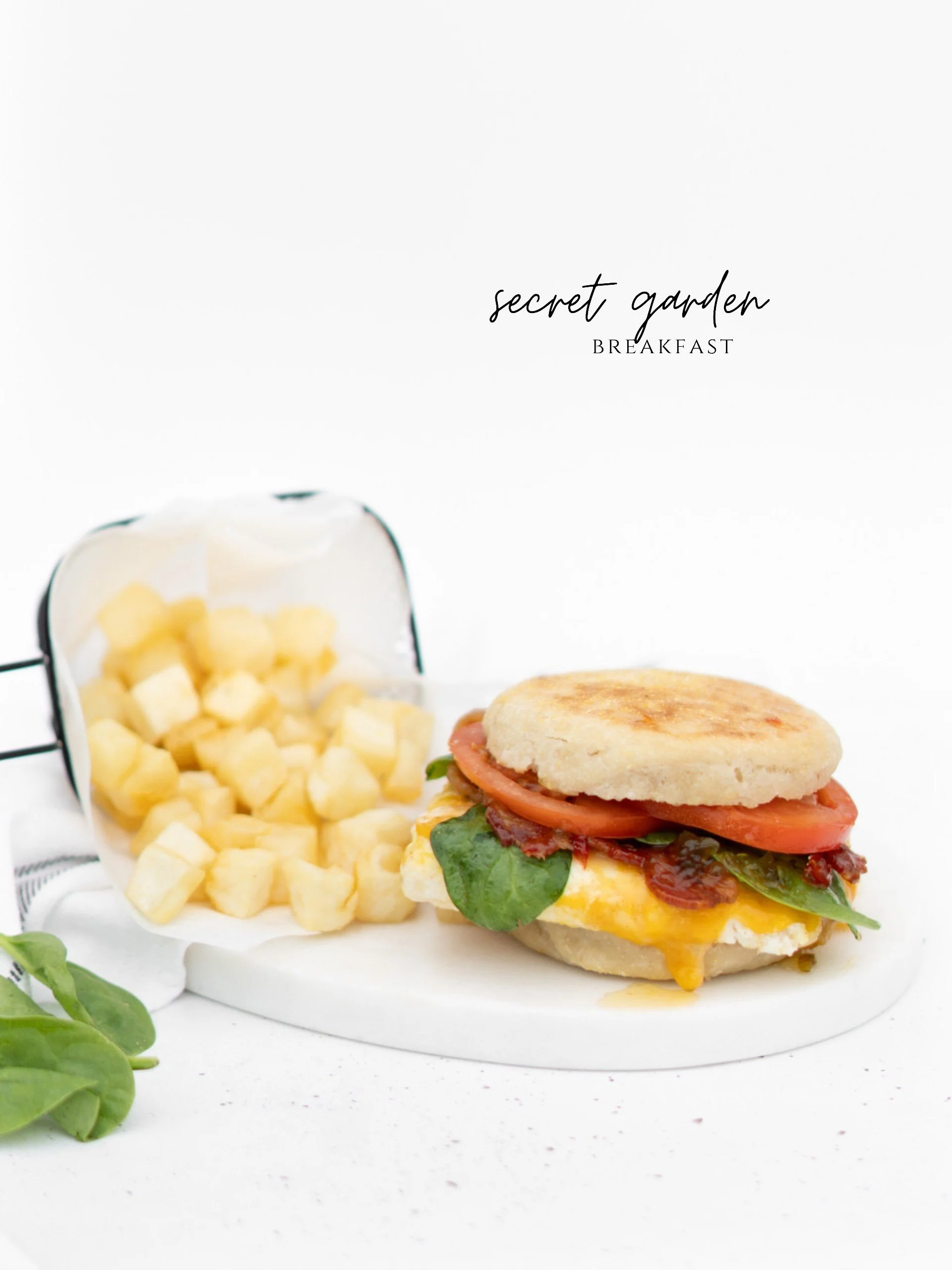 A toasted English muffin layered with your choice of sausage or bacon, a fried egg, melty cheese, pepper jelly, fresh tomato, and spinach. A savory breakfast sandwich with just the right touch of sweet heat.