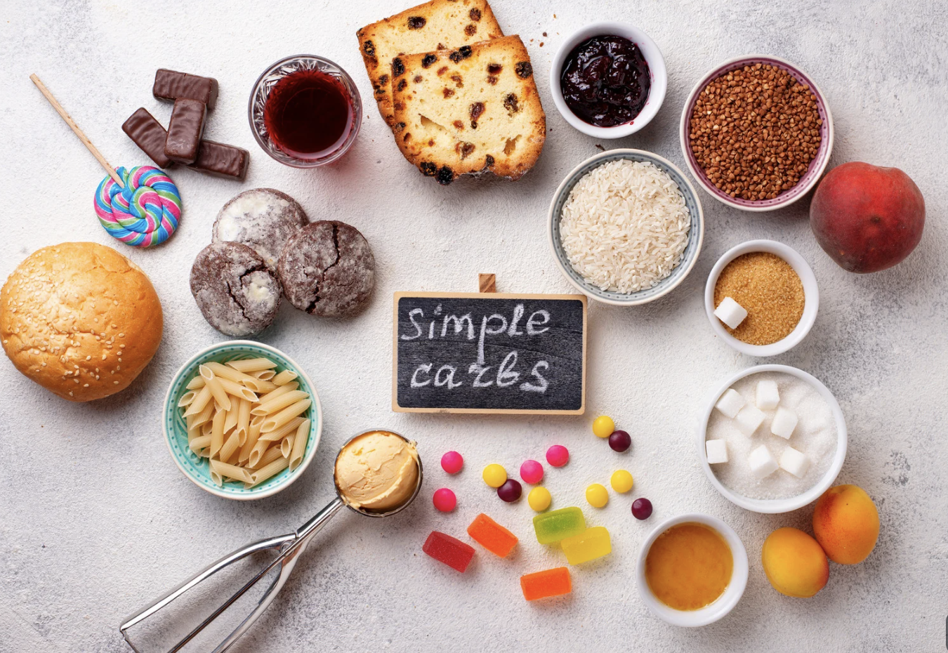 Selection of starchy and sugary foods including bread, pasta, rice and sweets.