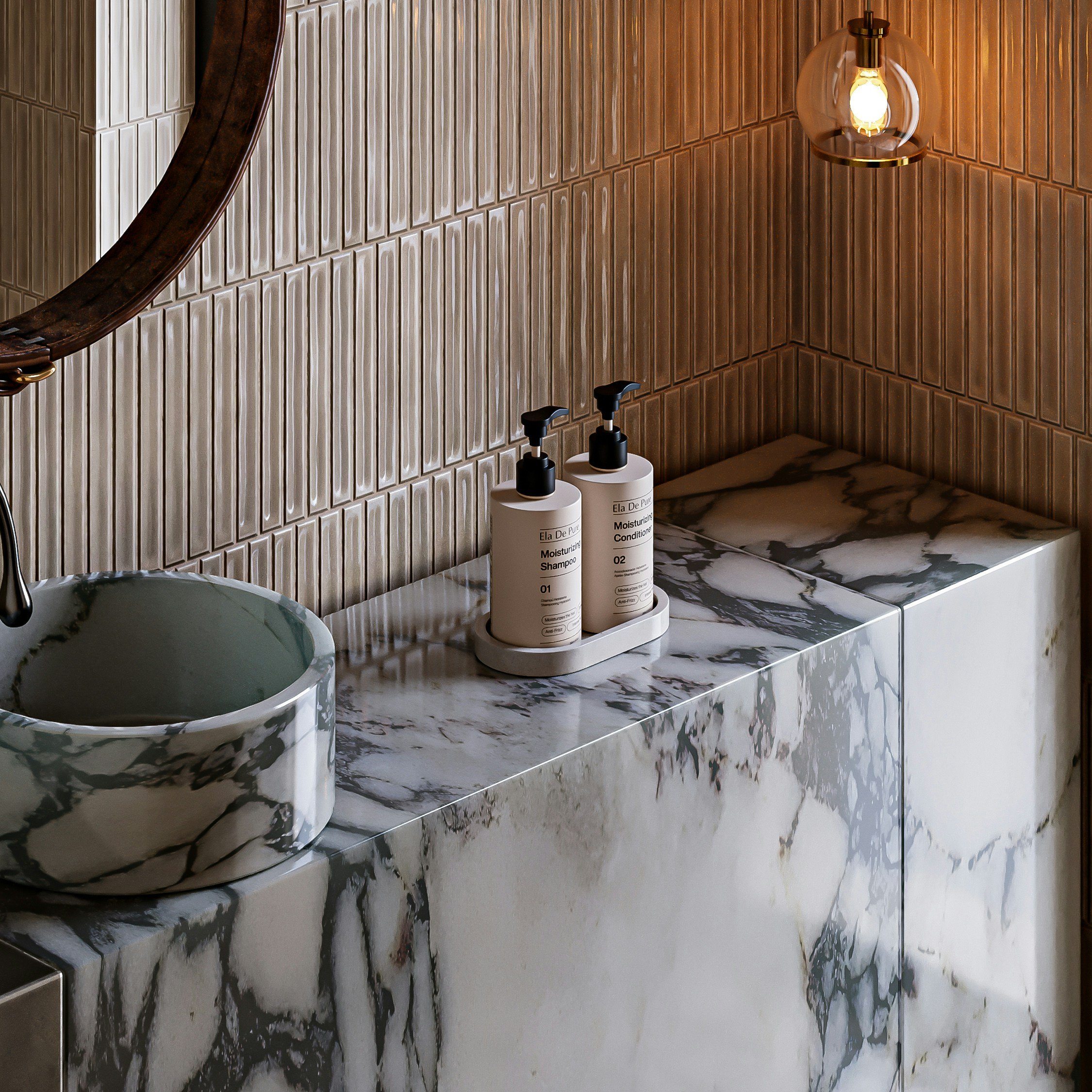 A bathroom countertop with toiletries and a round marble sink. The wall behind has beige tiles with a textured pattern, and there is a single wall-mounted light fixture.