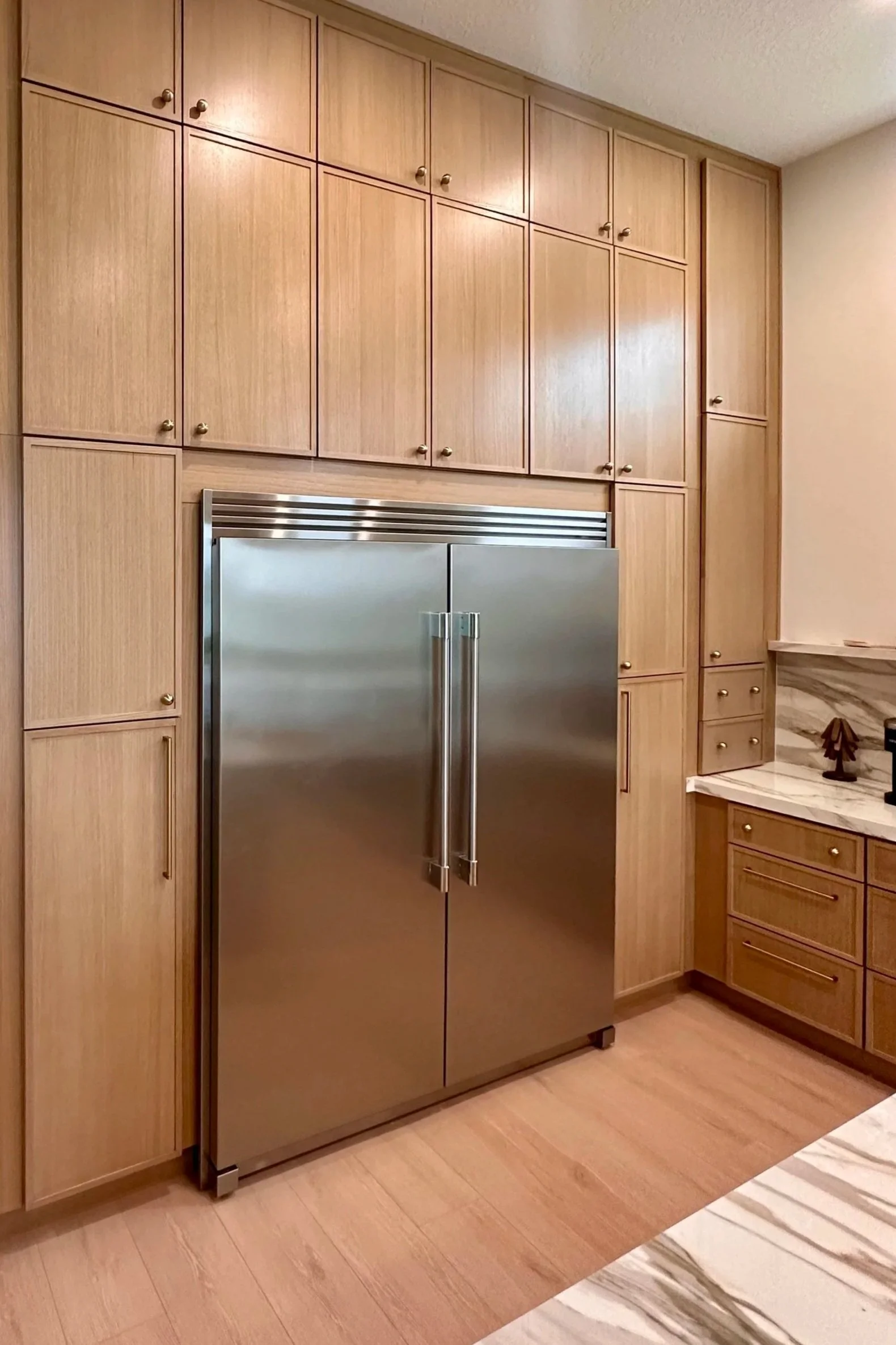Kitchen with wooden cabinets and stainless steel refrigerator.
