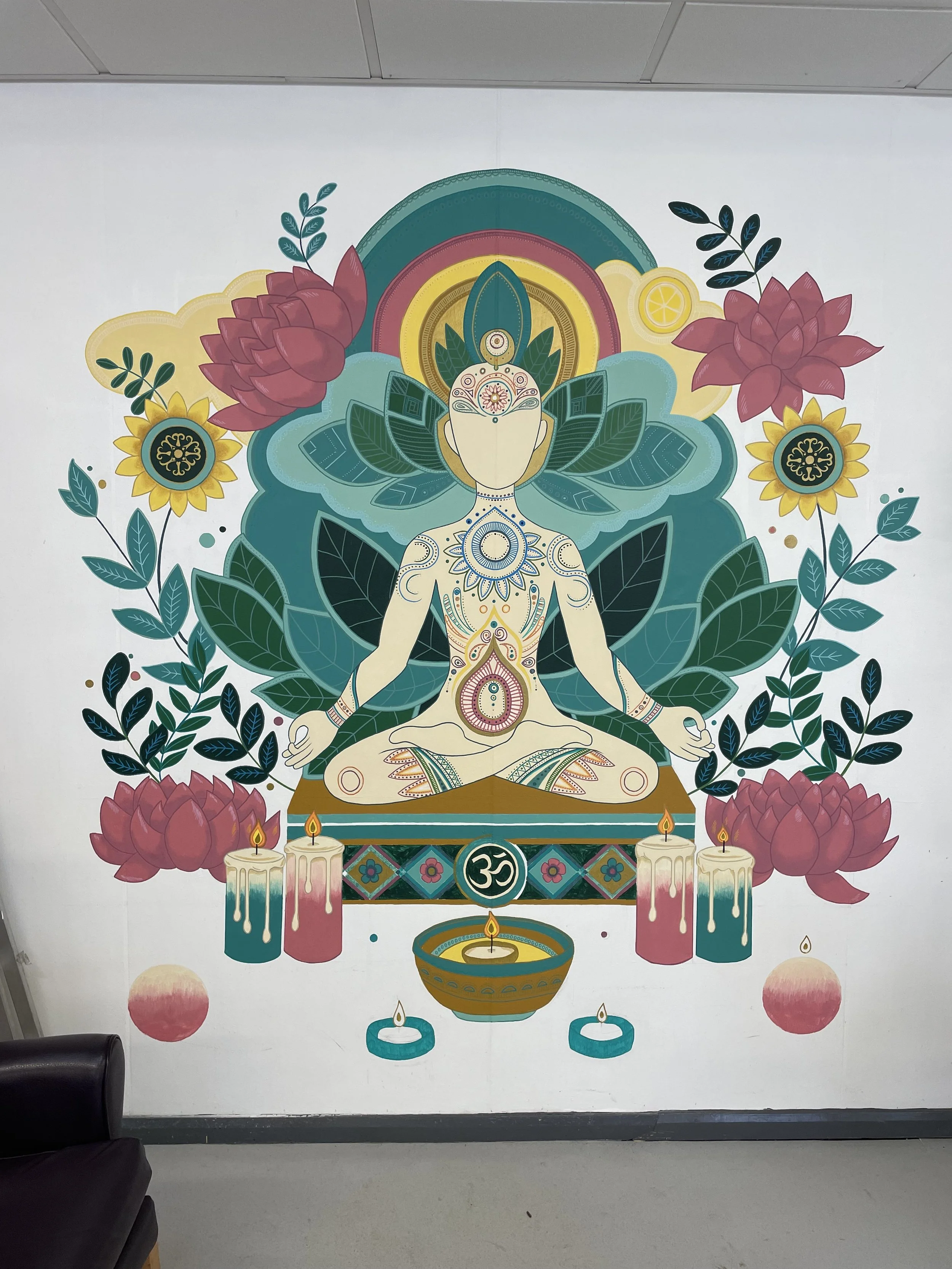 Colorful mural of a meditating figure surrounded by lotus flowers, candles, and leaves, with spiritual symbols and vibrant patterns.