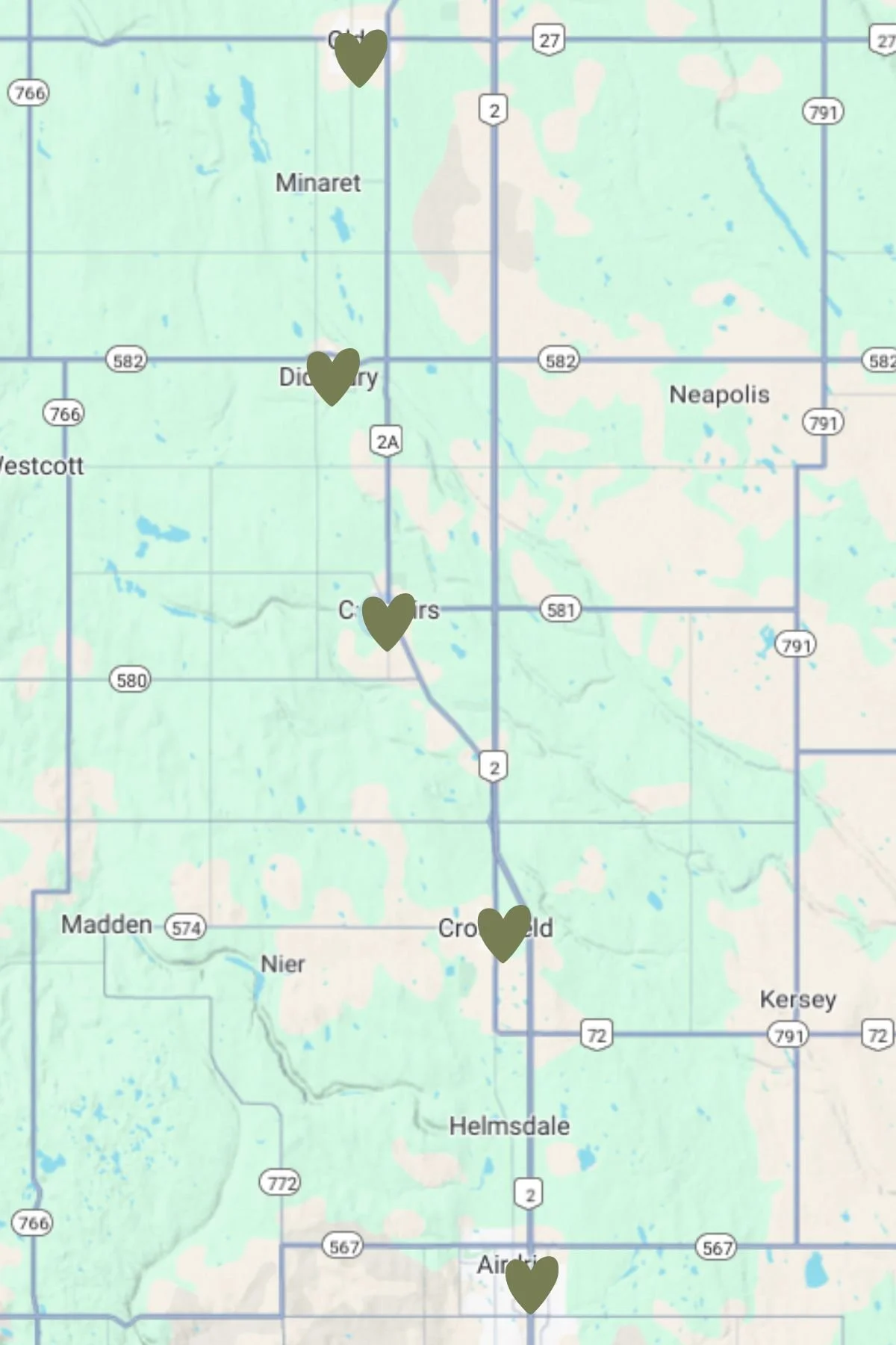 Map of a region in Michigan with five hearts marking locations along US Highway 2, from around Crossroads and Downer near the south to near the top of the map, with city names such as Minaret, Duckery, Neapolis, Crossroads, Madden, Helmsdale, and Airlee.