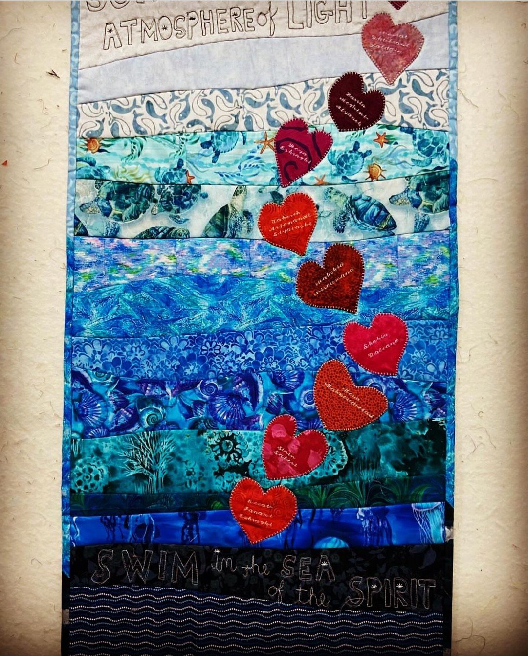 Beautiful embroidery from New Hampshire, United States, paying tribute to the 10 Bah&aacute;'&iacute; women of Shiraz. Each delicately embroidered heart, set against a backdrop of soothing blues, symbolizes the spirit and courage of these remarkable 