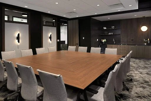 Custom square conference table with gray chairs. Moody conference room.