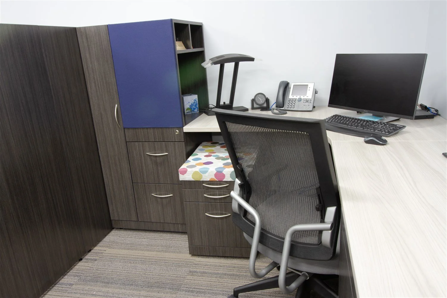Close up custom workstation with sit-stand desk, custom storage and movable storage bench