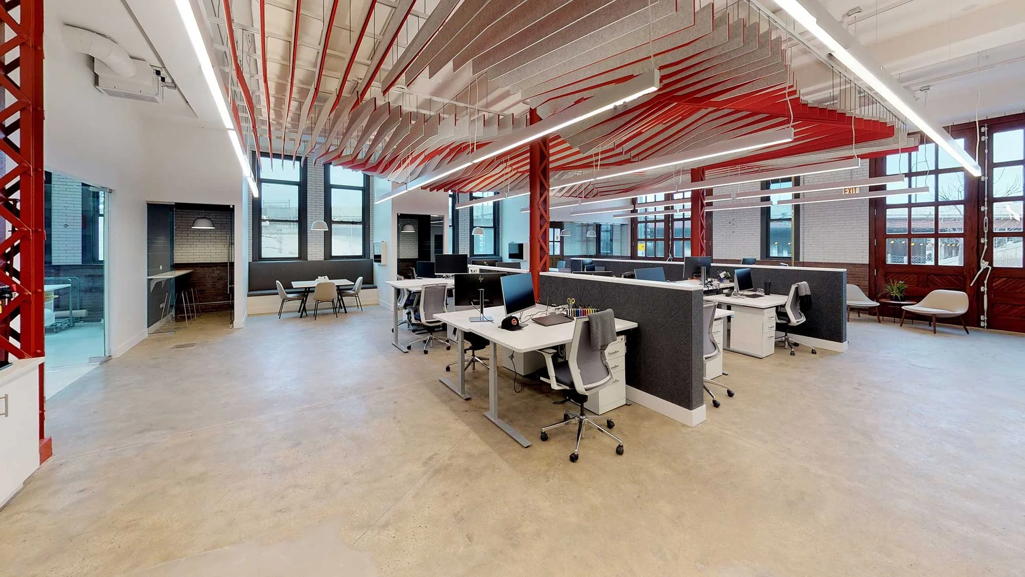 Open office modular workstation desk with modern pops of red in the ceiling