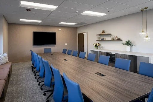 Long rectangular custom conference table with rich blue chairs