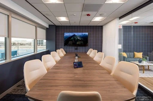 Keystone Conference Table in walnut finish in conference room with plaid accent wall