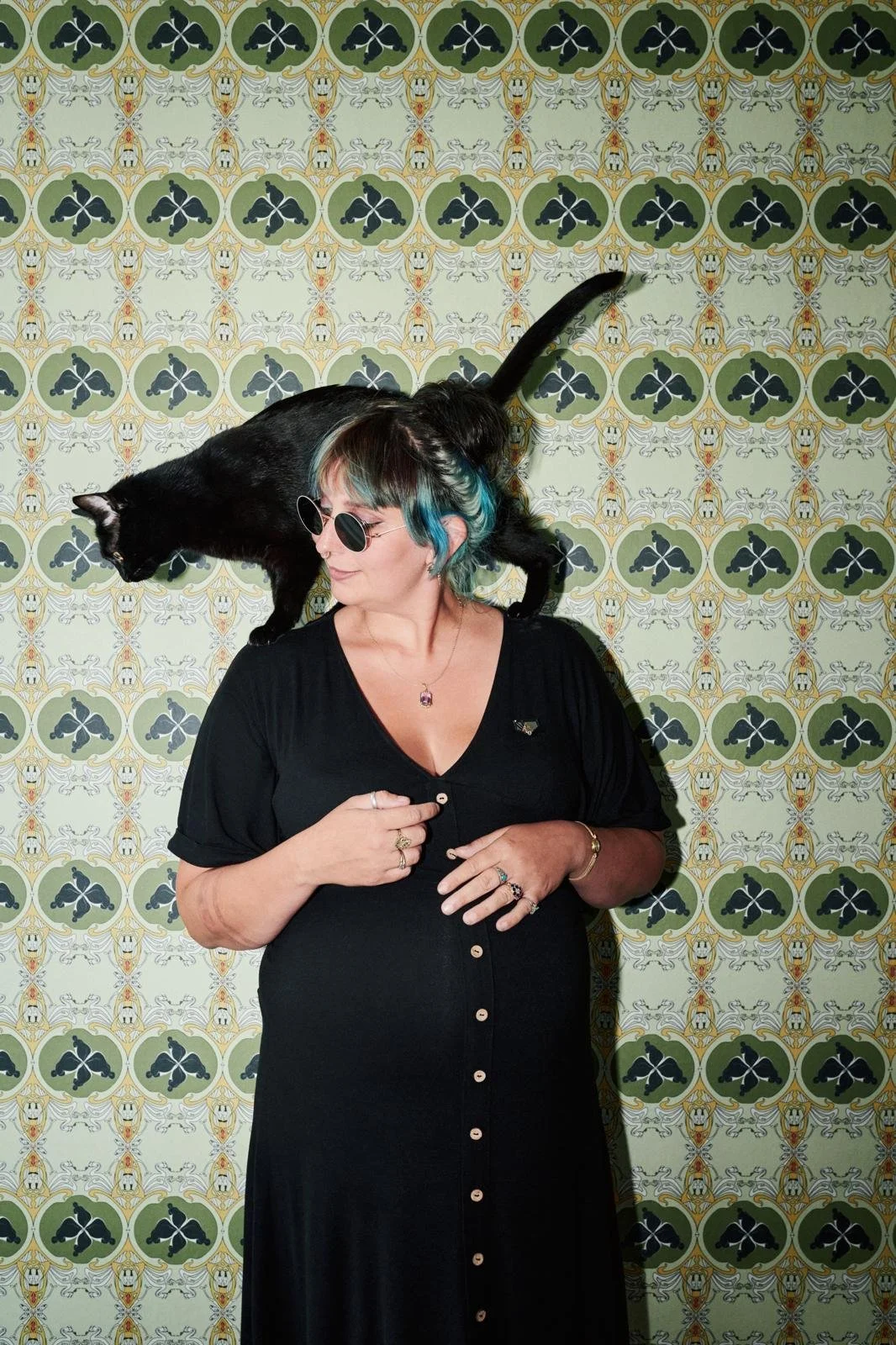 Künstlerin Paula Knaps Loos mit einer schwarzen Katze vor einer tapezierten Wand