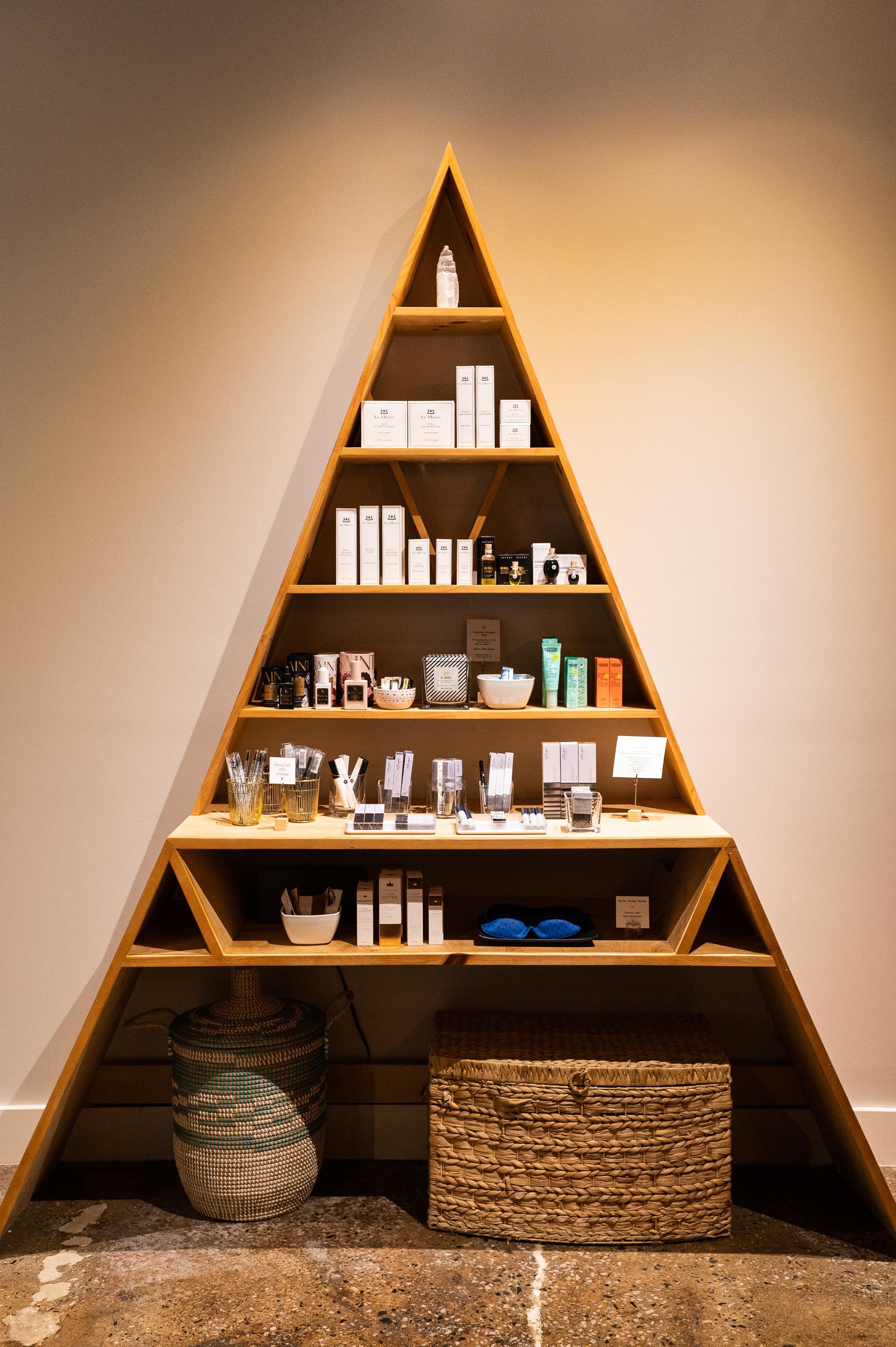 Pyramid shelf showcasing self-care and beauty products at The Brow House in Charlottesville VA