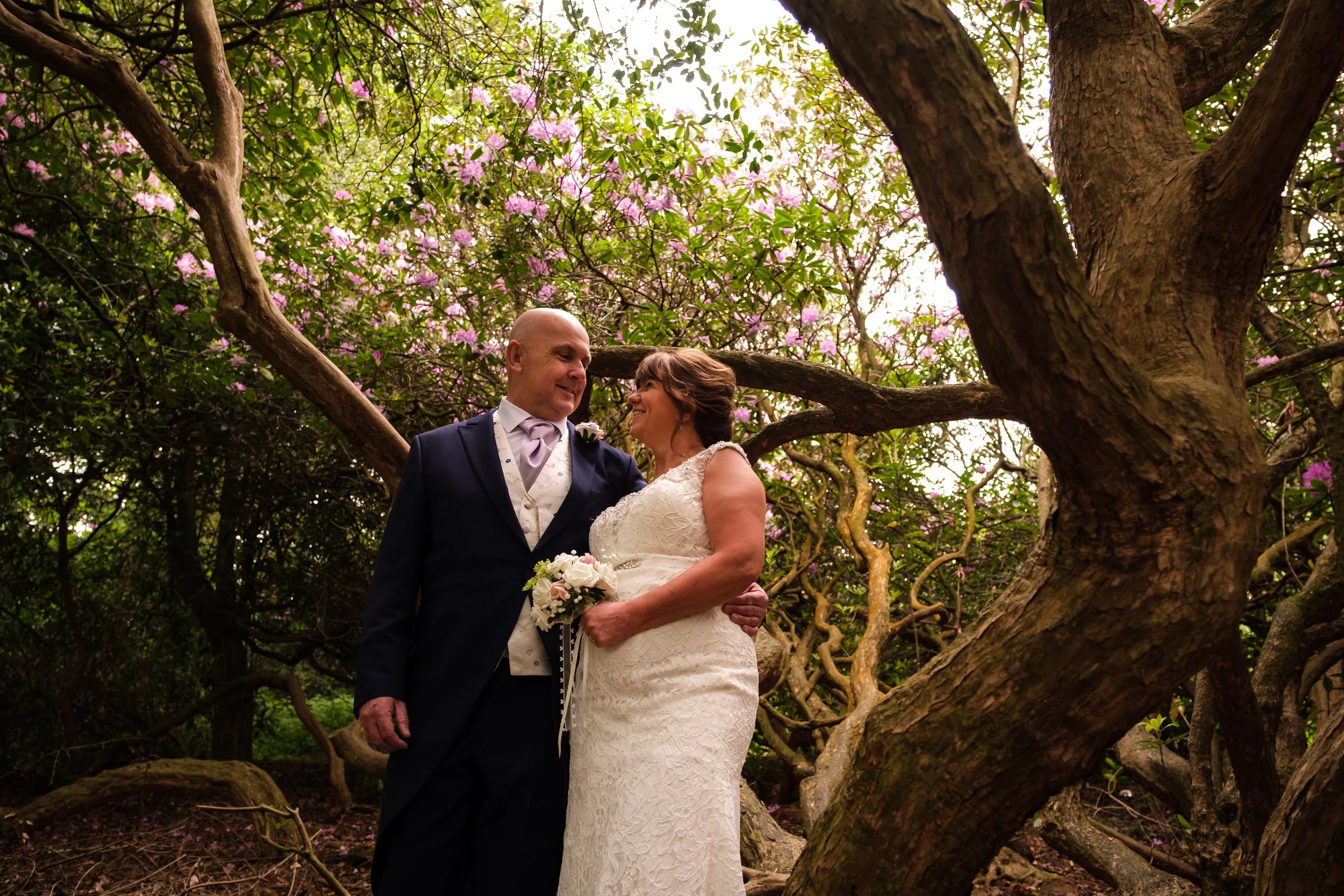 Bride & Groom pose in the Rhododendrons