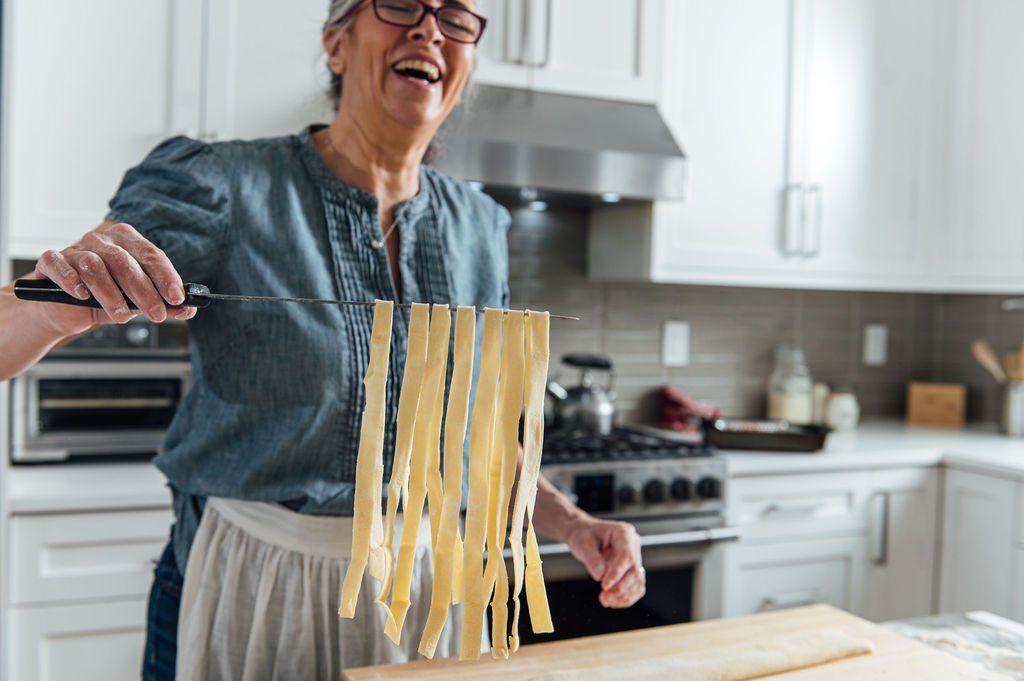 Older Chef of Stefania's kitchen in Portland, making pasta captured by  personal brand photographer