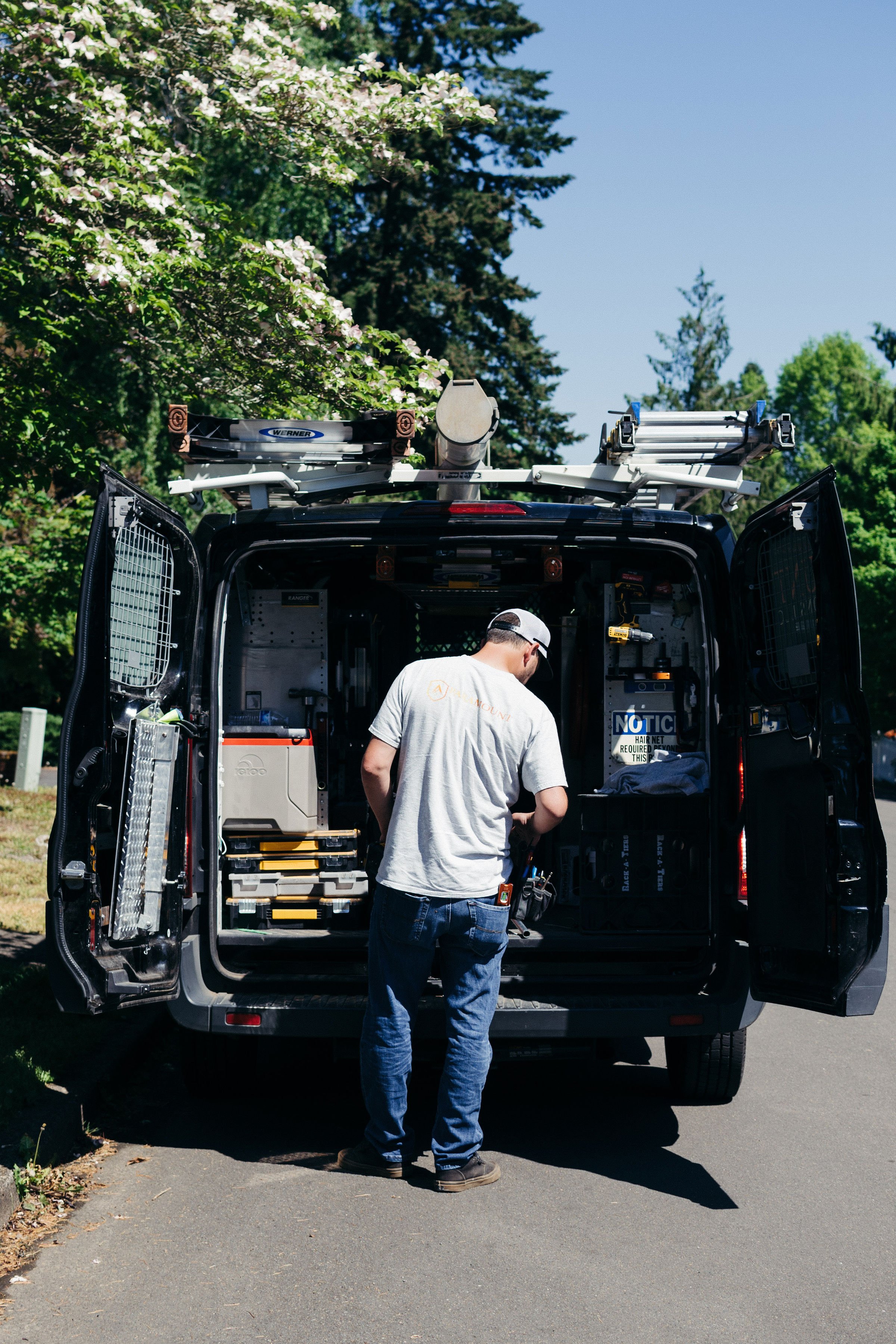 A worker loading a van with tools for Paramount Security Solutions in Portland, OR