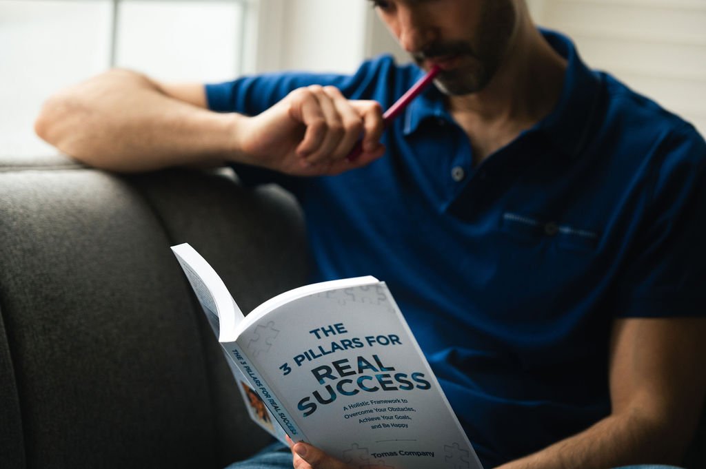 personal brand photographer capturing a man engrossed in a book while sitting on a couch