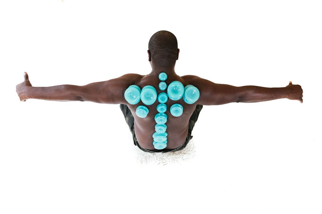 A man with blue massage balls on his back, posing for the best brand photographer in Portland, OR