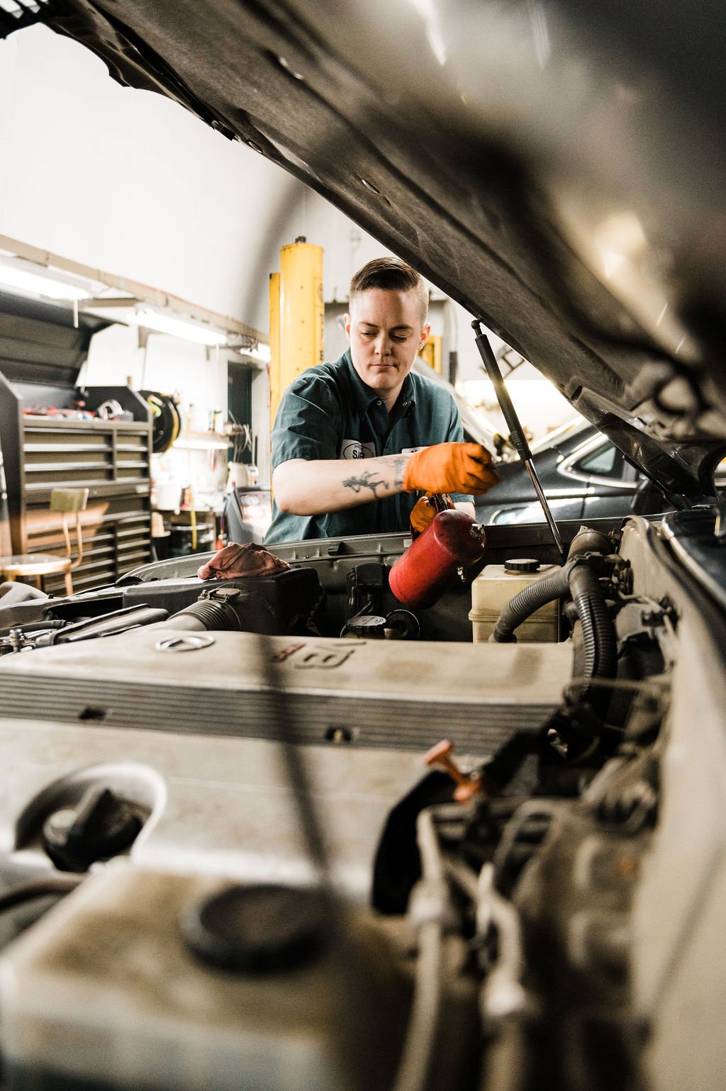 Portland branding photographer captures a mechanic fixing a car in an Auto Repair company’s garage.
