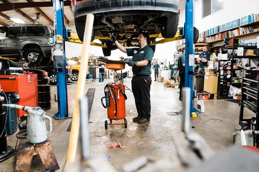 Business branding photography featuring a mechanic in an Auto Repair garage, modifying a car.