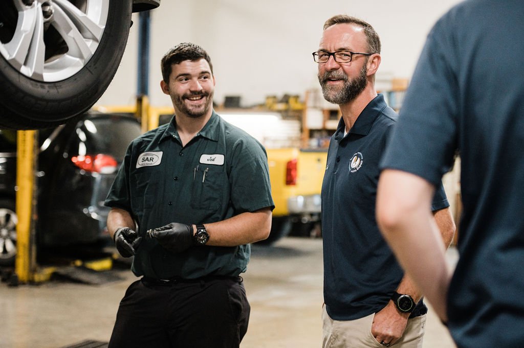 A couple of professionals engaged in conversation during a branding photoshoot at an Automotive Repair company.