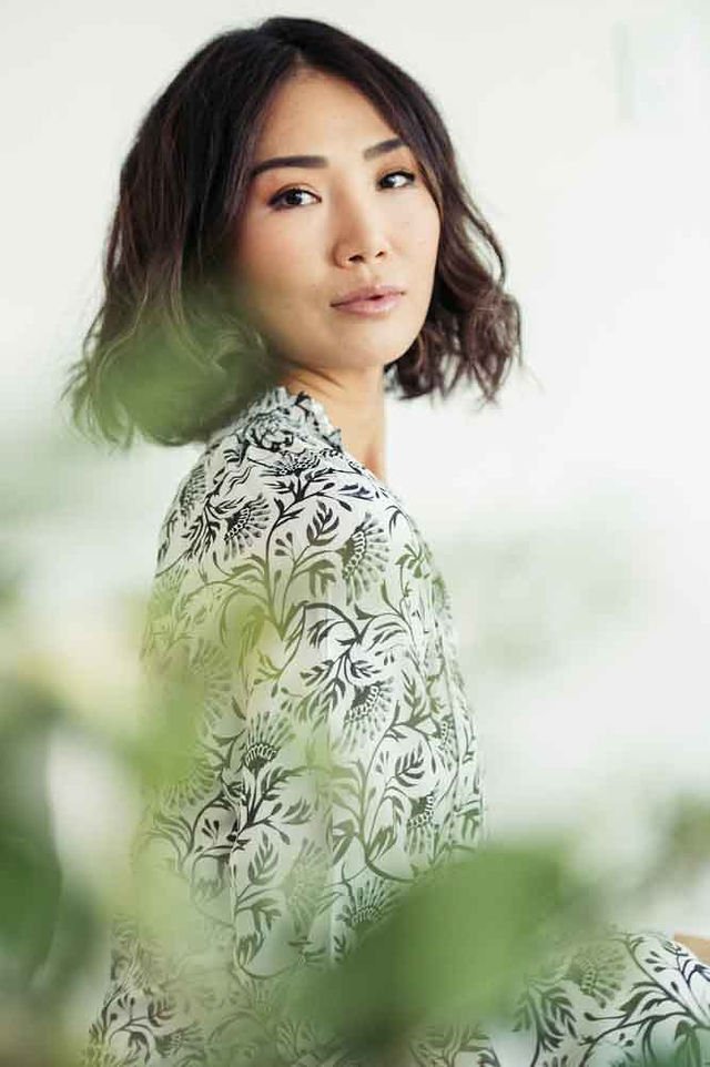 A woman wearing a branded white and black floral print shirt looks stylish and elegant.