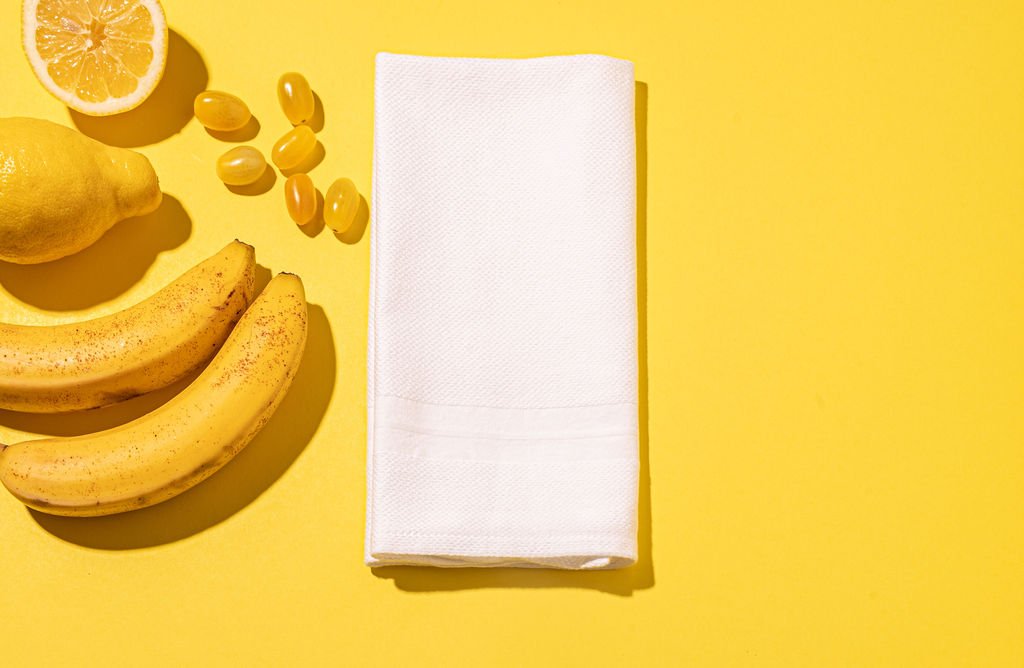 A yellow background with a white napkin and lemons represents ALT Linen company.