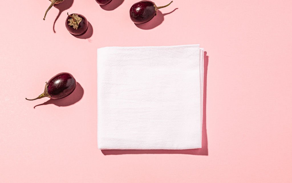 A soft white napkin and cherries on a pink background.