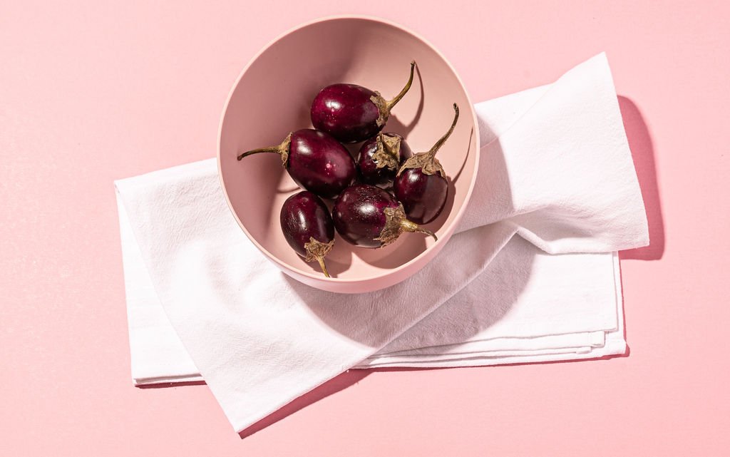 A captivating image of a bowl of cherries enhanced by a linen napkin, in a professional branding photography.