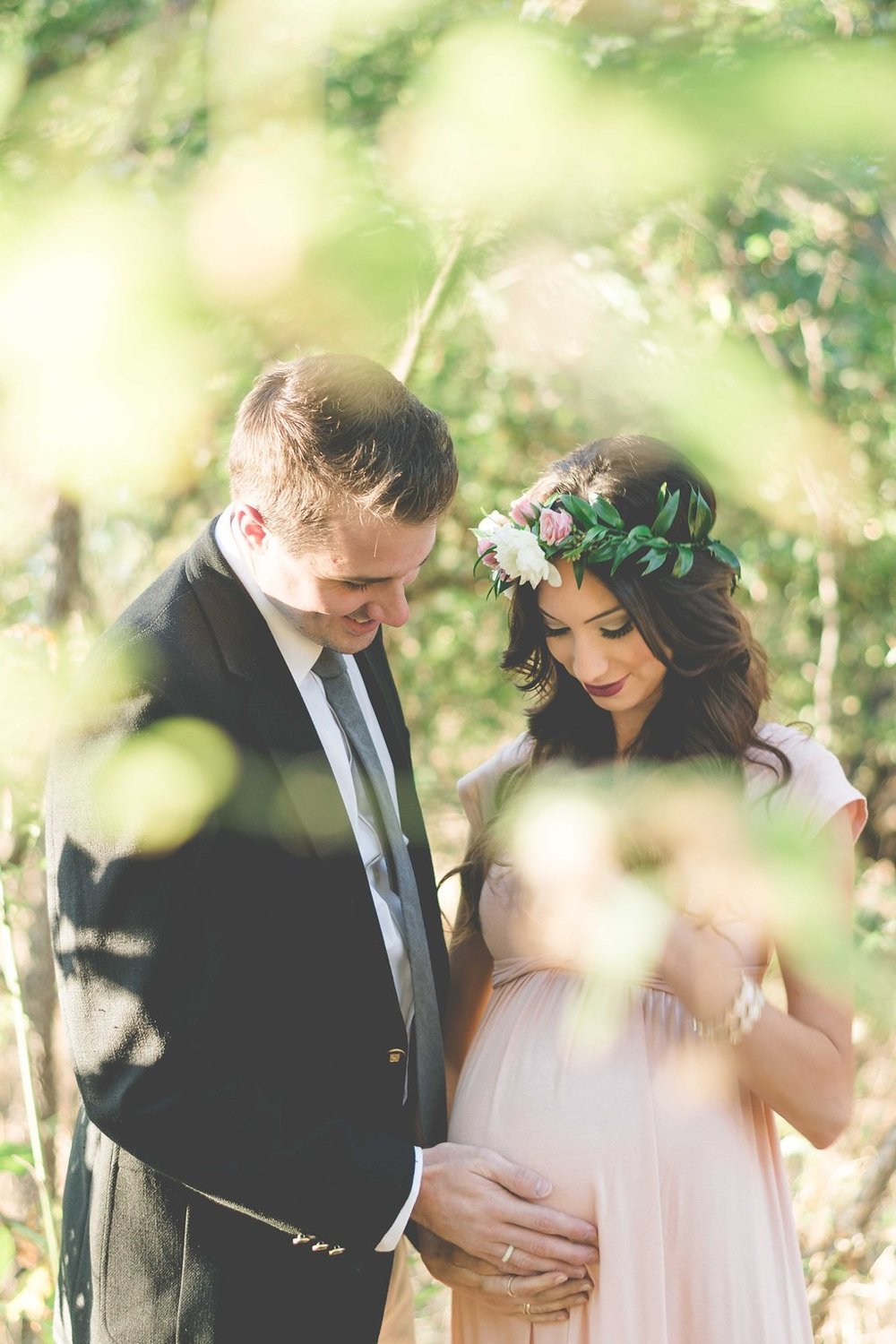A couple expecting a child poses for the best event photographer in a serene forest setting in.jpg