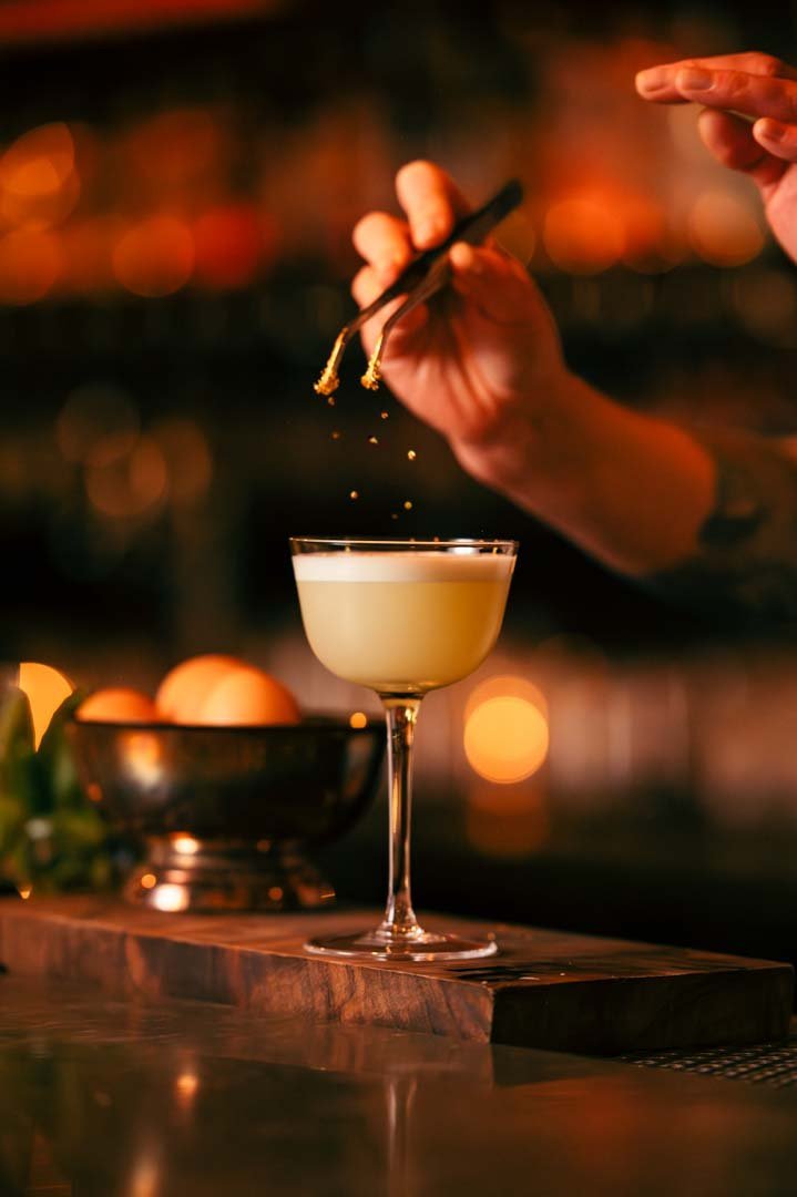 A bartender in Portland pours a cocktail into a glass. Exquisite drink photography capturing the art of mixology.jpg