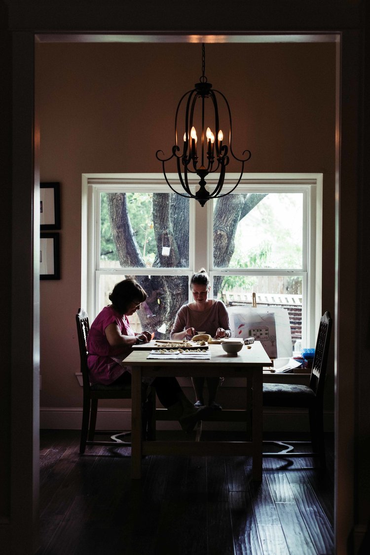 A captivating photo of two females dining at a table in front of a window, captured by a food photographer in Portland.jpg