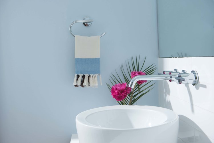 A bathroom with a white sink and a blue towel in the product photography session.jpg