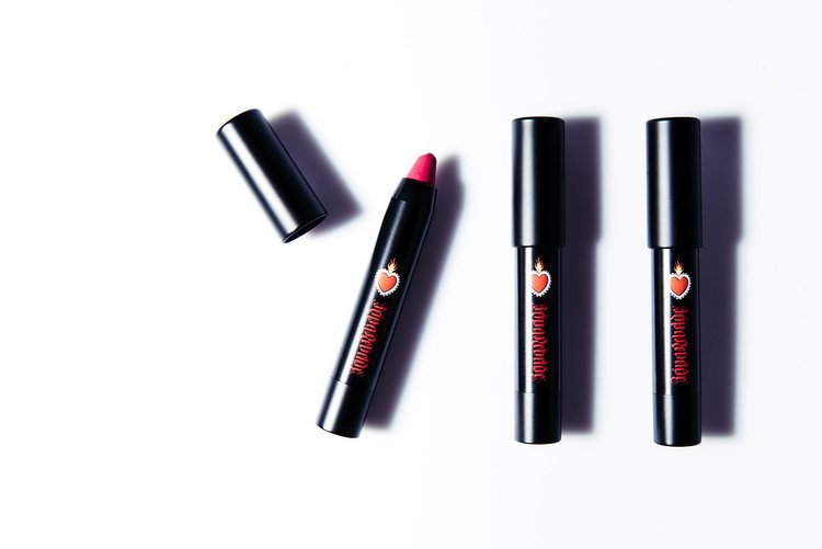 A cosmetic product photograph showcasing three lipsticks placed on a white surface.jpg