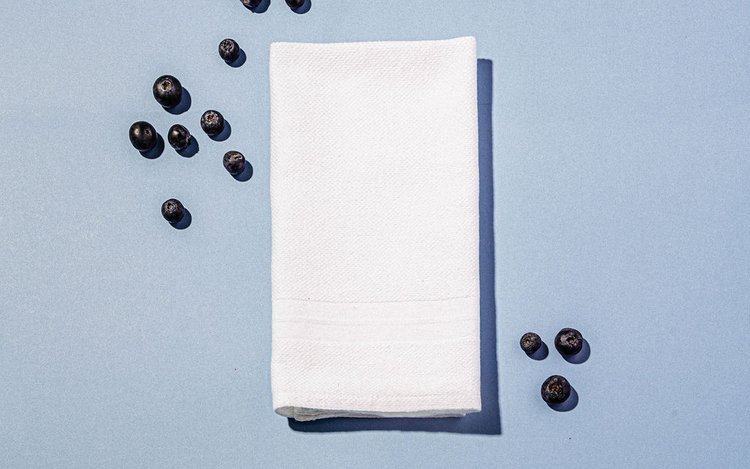 A napkin and coffee beans on a blue surface arranged by the best e-commerce product photographer on Instagram.jpg